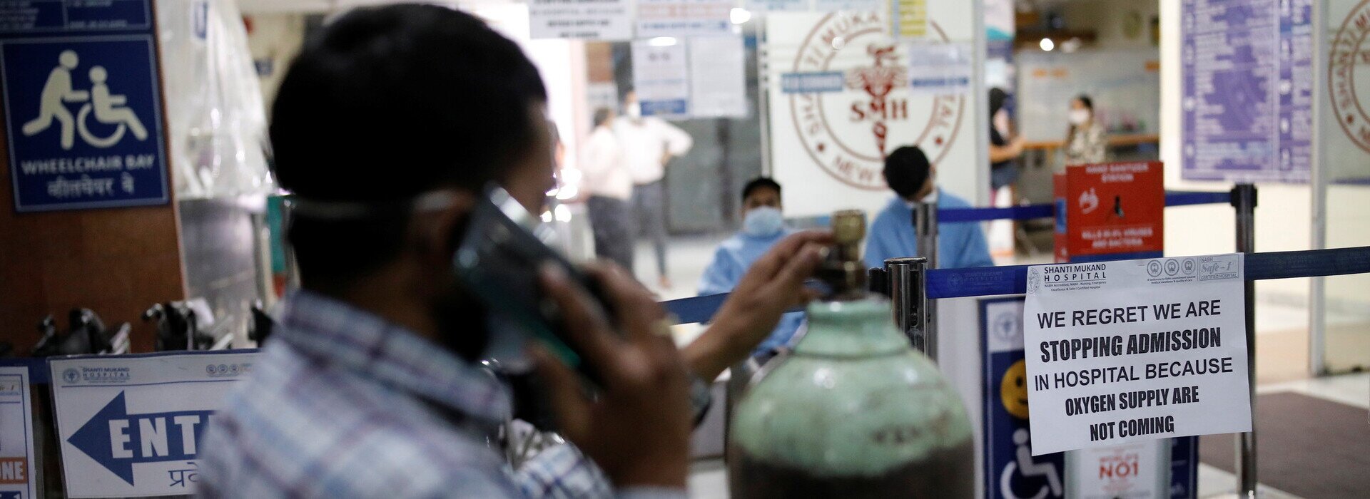 A man stands next to a notice outside a hospital that says: "We regret we are stopping admission in hospital because oxygen supply are not coming" amidst the spread of COVID-19 in New Delhi, India, April 22, 2021.