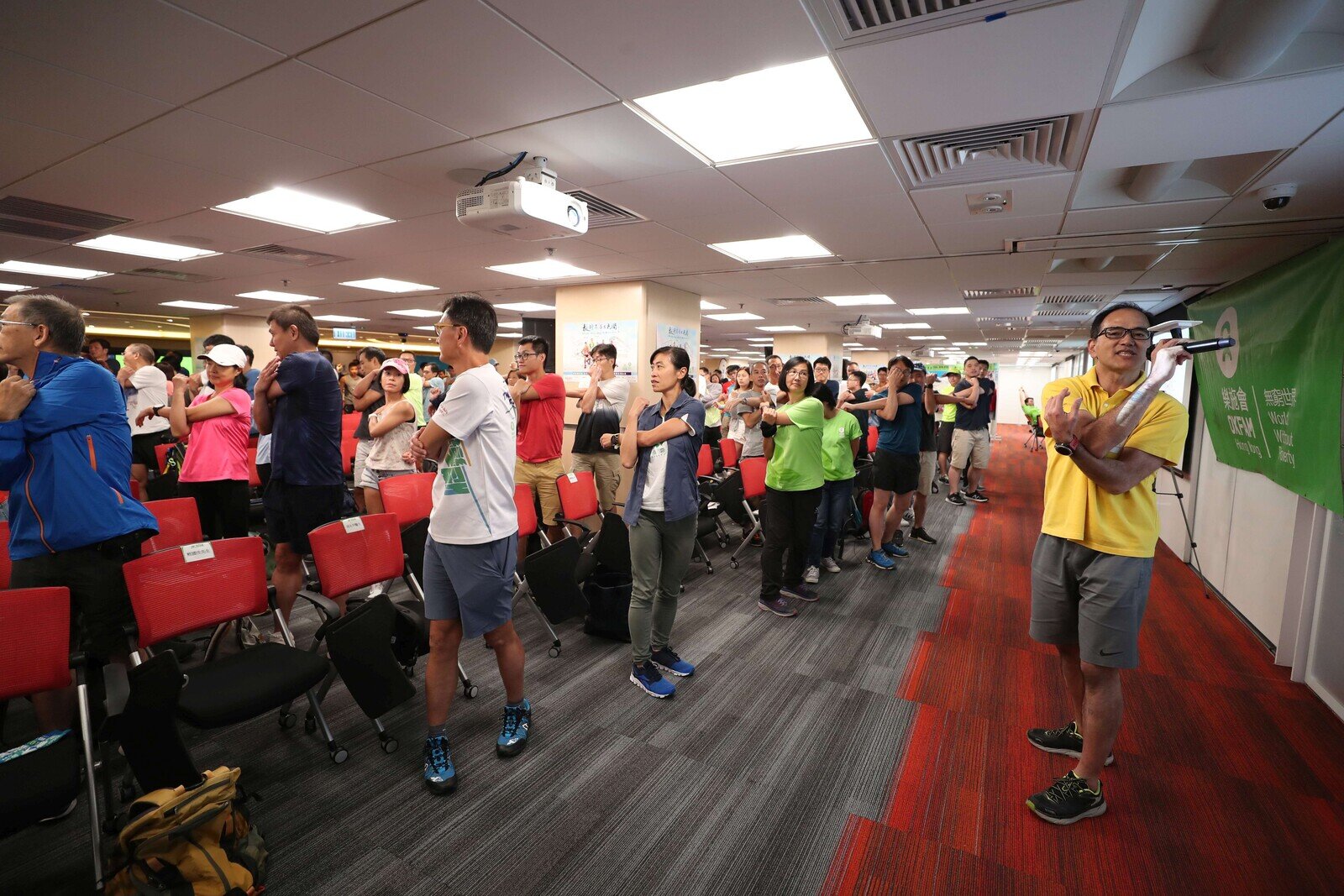 Almost 300 walkers at the Oxfam Trailwalker 2019 briefing learning warm-up exercises.