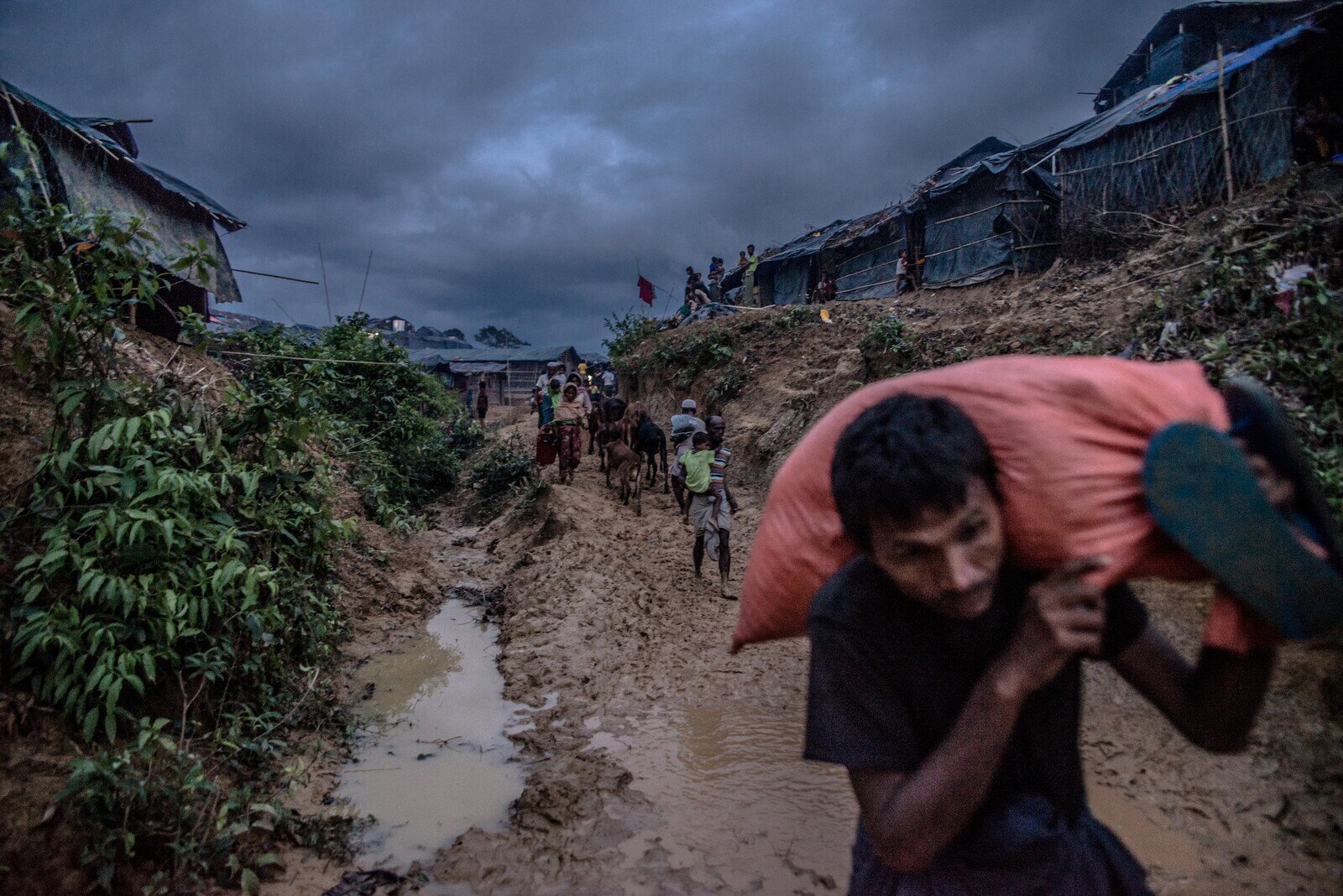 A Rohingya man carries a bag of donated food aid in Balukhali camp, Bangladesh. photo: Aurélie Marrier d'Unienville