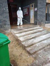 A volunteer disinfecting a building.