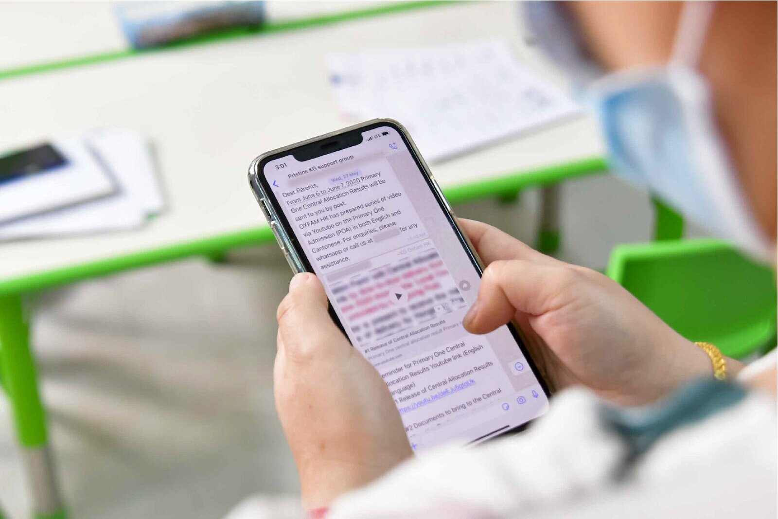 A parent reading information about Primary One Central Allocation results from Oxfam’s WhatsApp group that was created to support ethnic minority families.