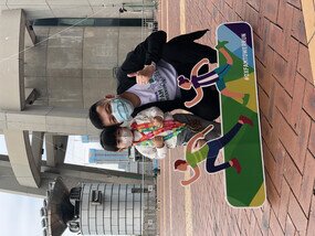 A man and child posing for the camera in front of the Macau Tower.