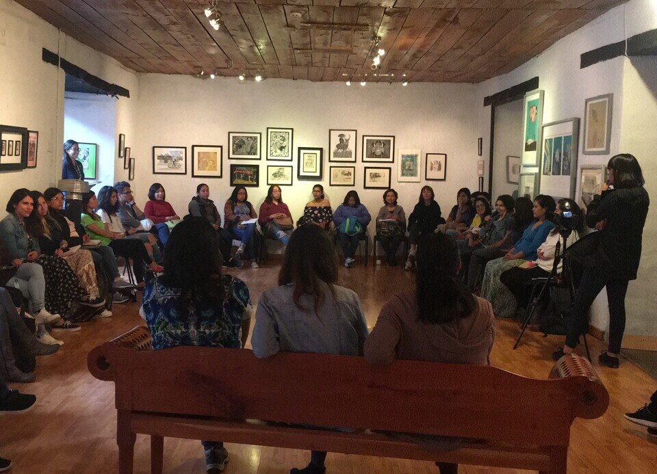 Women at a meeting in a large room.